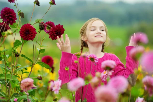 Bambina che annusa fiori viola — Foto Stock