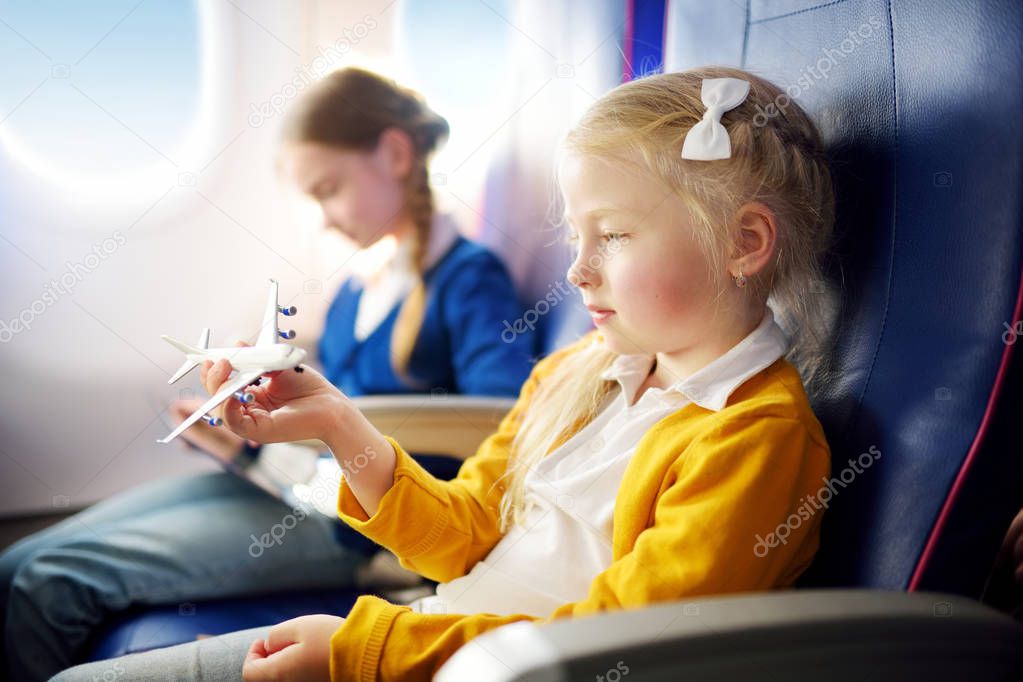 Adorable little girls traveling by an airplane.