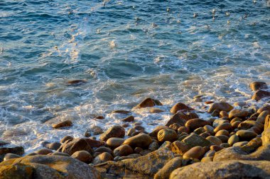 Büyük dalgalar üzerinde kayalık plaj kırma