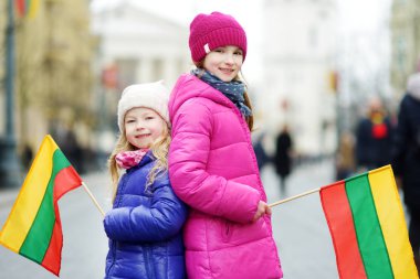 İki sevimli küçük kız Vilnius Litvanya üç renkli bayrak tutan Litvanya Bağımsızlık günü kutluyor
