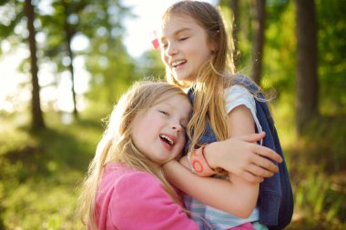İki sevimli küçük sarılma ve açık havada güzel yaz günü sarılma kız kardeş. Aile bağı.