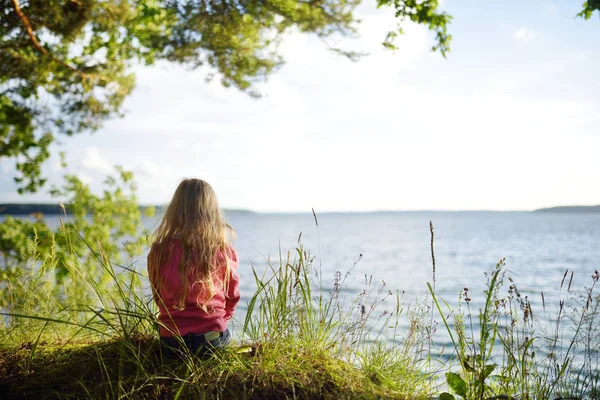 Güzel Gün Batımı Manzarayı Göl Kenarında Oturan Sevimli Küçük Kız — Stok fotoğraf