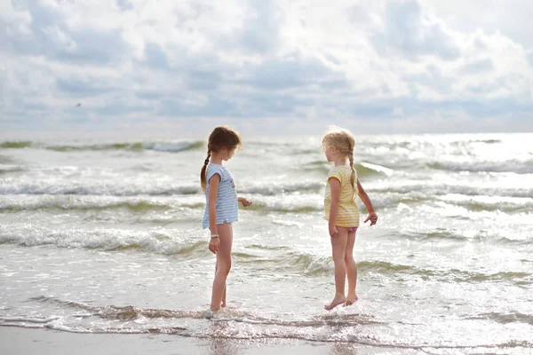 つの幼い姉妹が暖かく 日当たりの良い夏の日に砂浜のビーチで楽しんで 海で遊ぶ子供たち 子供のための夏の活動 — ストック写真