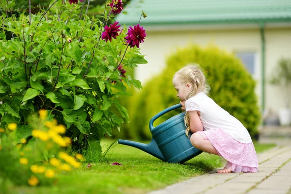 夏の日に庭の花に水をまくかわいい女の子 晴れた日にガーデン ホースを使用して子を Mommys リトル ヘルパー — ストック写真