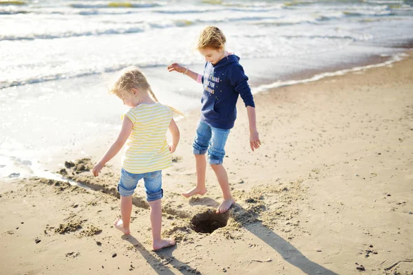 两个妹妹在温暖而晴朗的夏日里在沙滩上玩得很开心 孩子们在海边玩耍 儿童暑期活动 — 图库照片