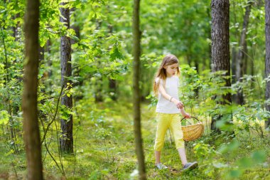 Sevimli küçük kız güzel yaz günü ormanda yürüyüş sırasında eğleniyor. Çocuklarla etkin aile boş.