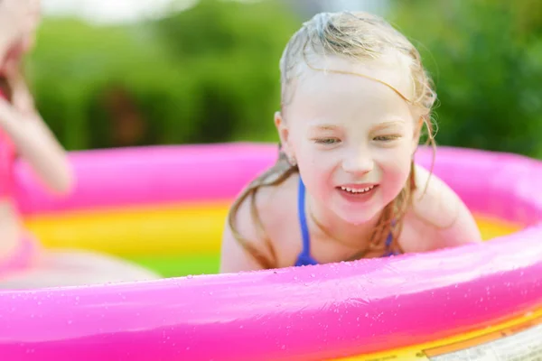 可爱的小女孩在充气婴儿池里玩耍 快乐的孩子溅在五颜六色的花园玩耍中心在炎热的夏日 儿童暑期活动 — 图库照片