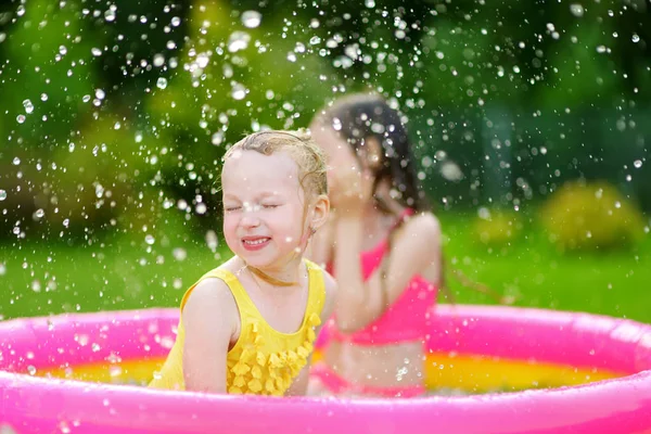 膨脹可能な赤ん坊のプールで遊ぶ愛らしい女の子 カラフルな庭の中で水しぶき幸せな子供たちは 夏の暑い日にセンターを再生します 子供のための夏の活動 — ストック写真