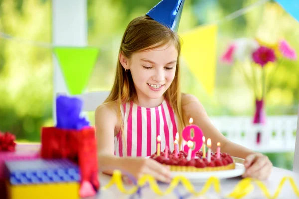 愛らしい少女の家で誕生日パーティー バースデー ケーキにろうそくを吹いてします 子供のカラフルな装飾 ギフトのバナーと誕生日パーティー — ストック写真