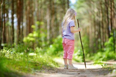 Sevimli küçük kız güzel yaz günü ormanda yürüyüş sırasında eğleniyor. Çocuklarla etkin aile boş.