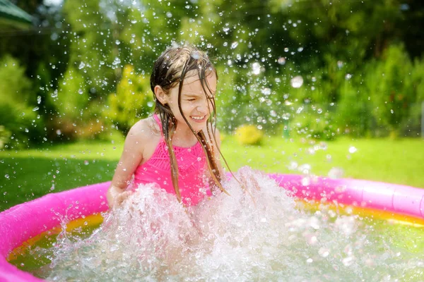 可爱的小女孩在充气婴儿池里玩耍 快乐的孩子溅在五颜六色的花园玩耍中心在炎热的夏日 儿童暑期活动 — 图库照片