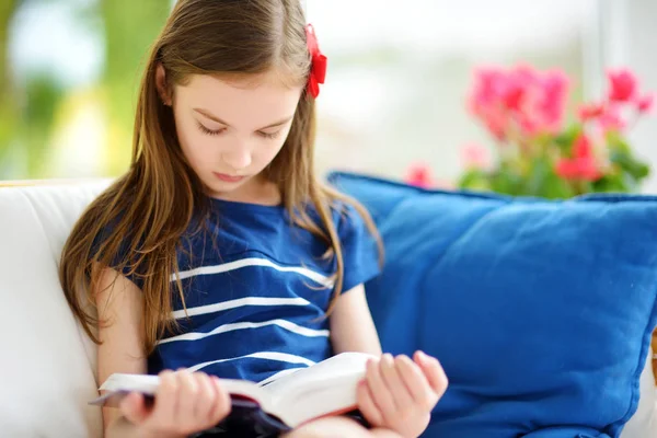 Meisje leesboek in woonkamer — Stockfoto