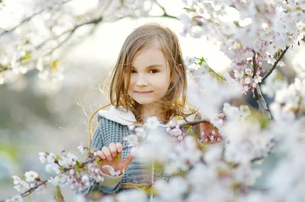 Malá holčička v rozkvetlé zahradě — Stock fotografie