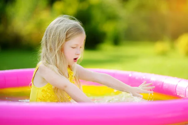 Meisje spelen in opblaasbaar zwembad — Stockfoto