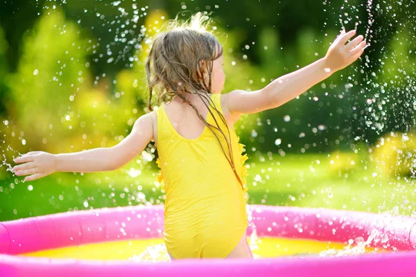 Bambina che gioca in piscina gonfiabile — Foto Stock