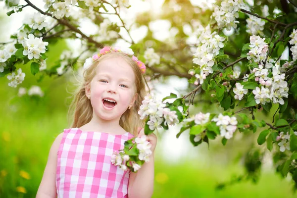 Liten flicka i blommande trädgård — Stockfoto