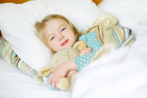 Malá holka ležící v posteli — Stock fotografie