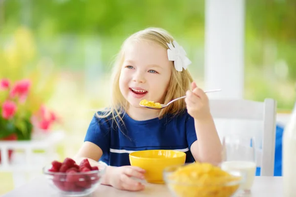 Liten flicka äta corn flakes — Stockfoto