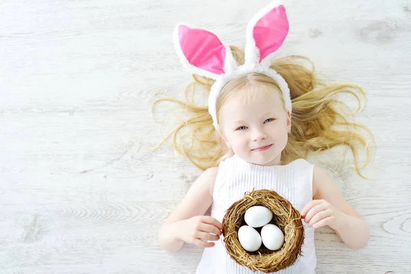 Chica jugando a la caza de huevos en Pascua — Foto de Stock