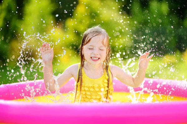 Liten flicka som leker i uppblåsbar pool — Stockfoto