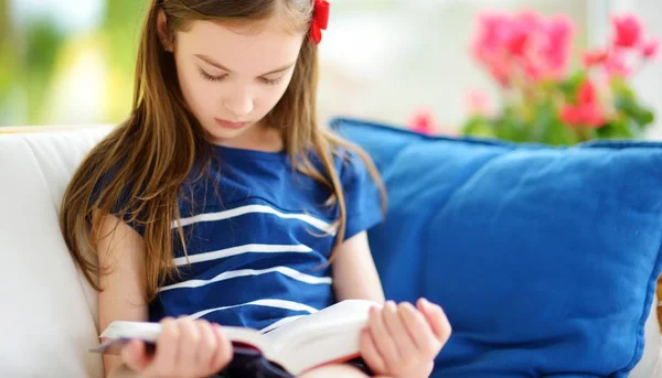 Meisje leesboek in woonkamer — Stockfoto