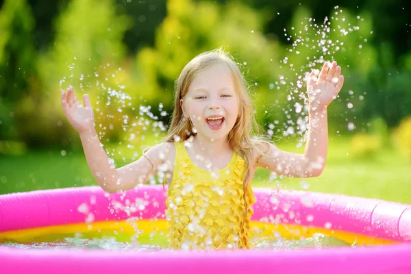 Маленькая девочка играет в надувном бассейне — стоковое фото