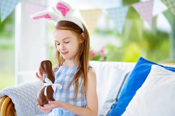 Linda niña comiendo conejo de Pascua — Foto de Stock