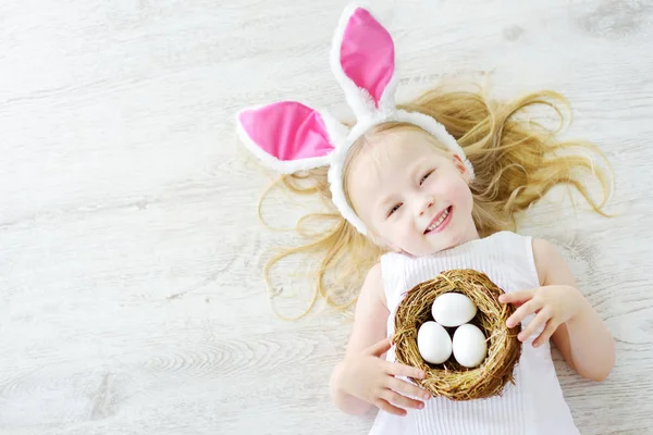 Chica jugando a la caza de huevos en Pascua — Foto de Stock