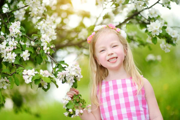 Liten flicka i blommande trädgård — Stockfoto