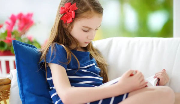 Mädchen liest Buch im Wohnzimmer — Stockfoto