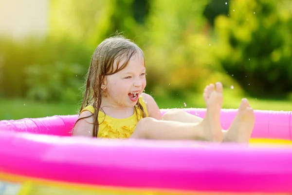Kleines Mädchen spielt im aufblasbaren Pool — Stockfoto
