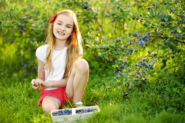 Kleines Mädchen pflückt frische Beeren — Stockfoto