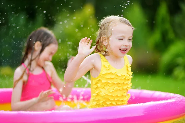 Девушки, играющие в надувном бассейне — стоковое фото