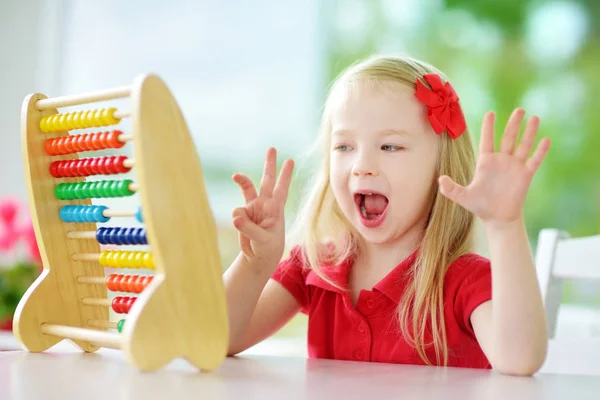 Liten flicka som leker med trä abacus — Stockfoto