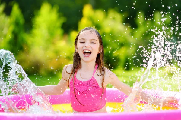 Menina brincando na piscina inflável — Fotografia de Stock