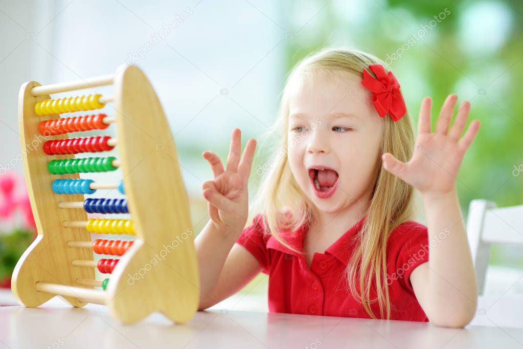 little girl playing with wooden abacus