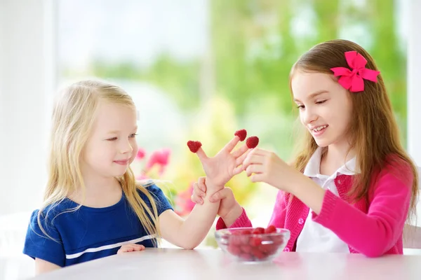 Niñas comiendo frambuesas en casa —  Fotos de Stock