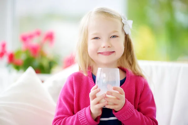 Маленькая девочка пьет органическое молоко — стоковое фото