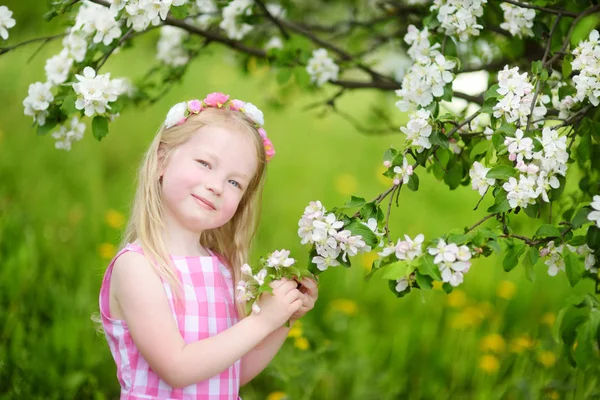 Malá holčička v rozkvetlé zahradě — Stock fotografie