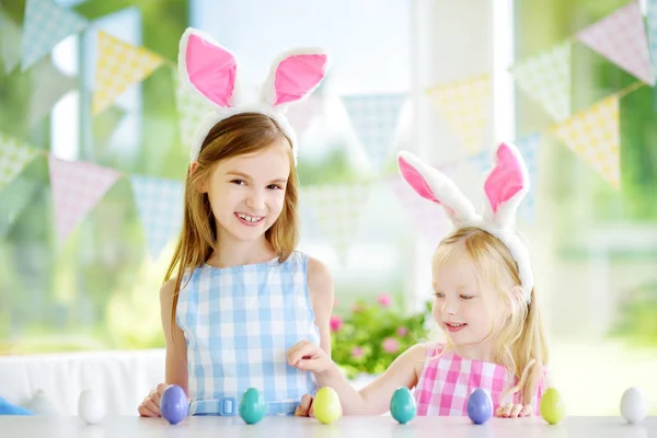 Hermanas jugando a la caza de huevos en Pascua — Foto de Stock