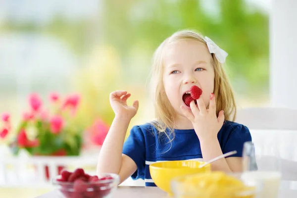 Malá holčička jíst Kukuřičné vločky — Stock fotografie