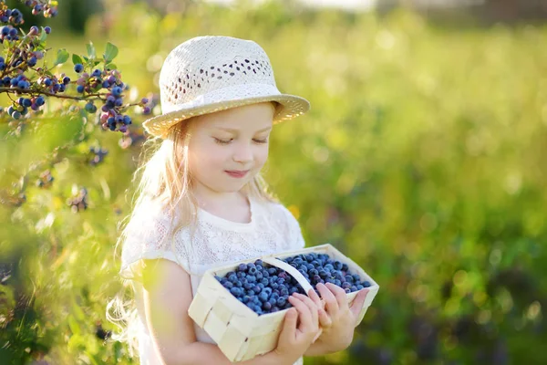 Kleine meisje plukken verse bessen — Stockfoto