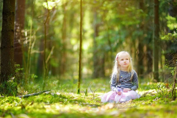 Klein meisje plukken bloemen in bos — Stockfoto