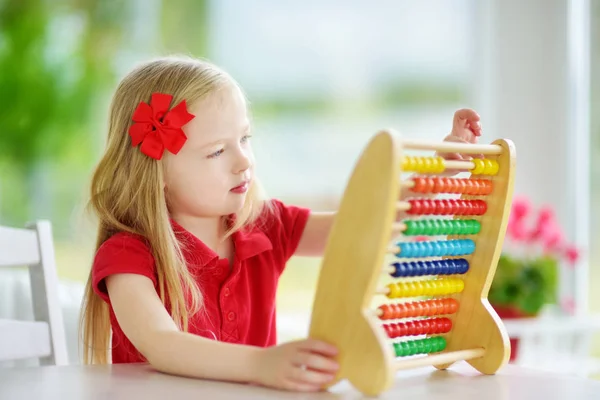 Niña jugando con ábaco de madera —  Fotos de Stock