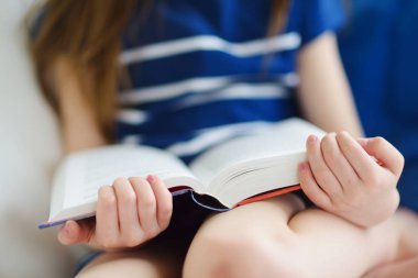 Oturma odasında kız okuma kitabı