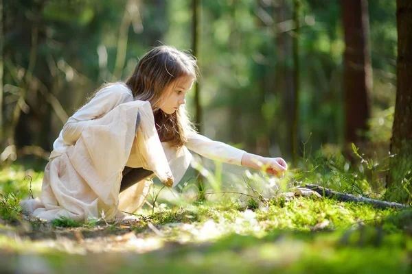 Kleines Mädchen pflückt Blumen im Wald — Stockfoto