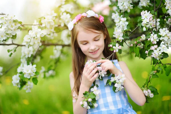 Liten flicka i blommande trädgård — Stockfoto