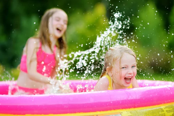 Meninas que jogam na piscina inflável do bebê — Fotografia de Stock