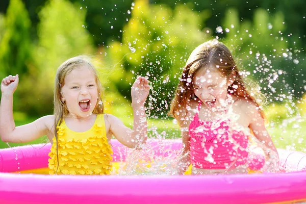Girls playing in inflatable baby pool — Stock Photo, Image