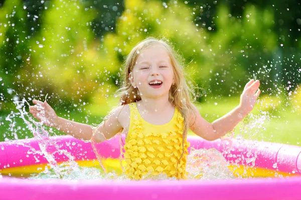 Kleines Mädchen spielt im aufblasbaren Pool — Stockfoto